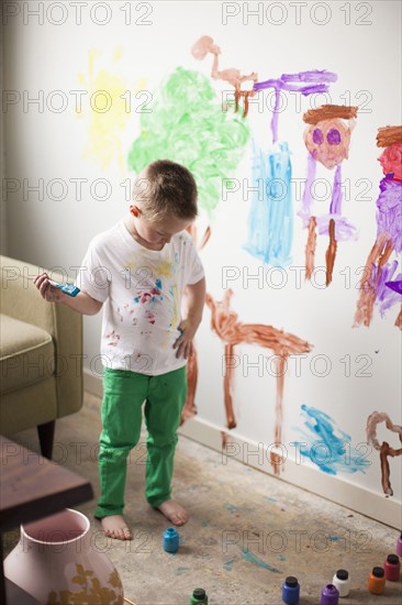 Toddler boy (2-3) painting on wall. 
Photo : Jessica Peterson