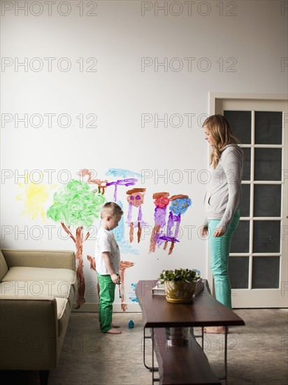 Mother telling toddler boy (2-3) off for painting on walls. 
Photo : Jessica Peterson