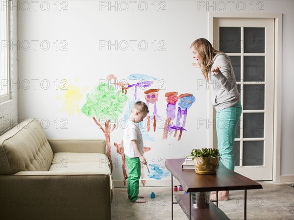 Mother telling toddler boy (2-3) off for painting on walls. 
Photo : Jessica Peterson