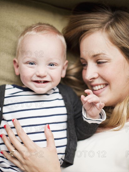 Mother and baby boy (12-17 months) lying in bed. 
Photo : Jessica Peterson