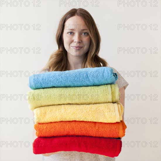 Young woman holding stack of multi-coloured towels.
Photo: Jessica Peterson
