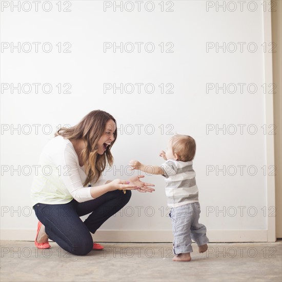 Young mother assisting baby boy (6-11 months) in first steps. 
Photo : Jessica Peterson