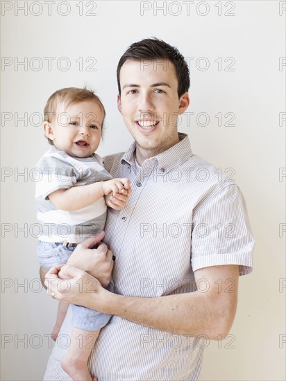 Father and baby boy (6-11 months) posing for portrait.
Photo : Jessica Peterson