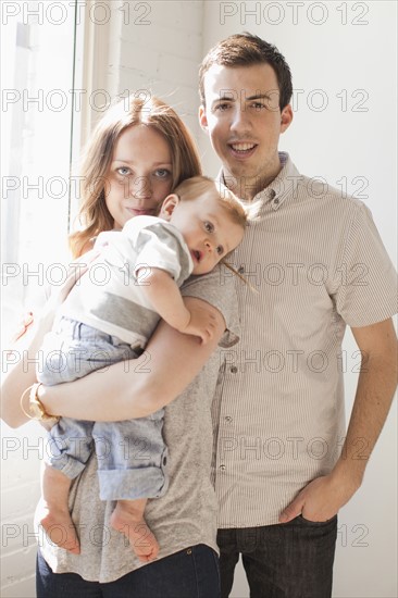 Young couple embracing baby boy (6-11 months) . 
Photo : Jessica Peterson