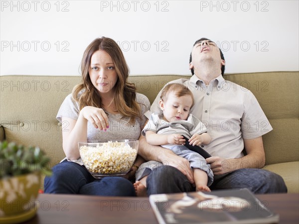 Young couple with baby boy (6-11 months) watching TV. 
Photo: Jessica Peterson