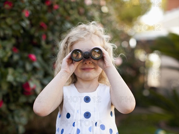 Young girl (4-5) looking through binoculars. 
Photo: Jessica Peterson