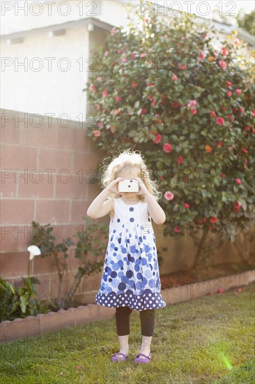 Young girl (4-5) using photographic camera. 
Photo : Jessica Peterson