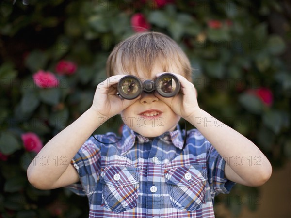 Young boy (6-7) looking through binoculars. 
Photo : Jessica Peterson