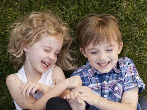 Girl (4-5) and boy (6-7) playing on grass. 
Photo : Jessica Peterson