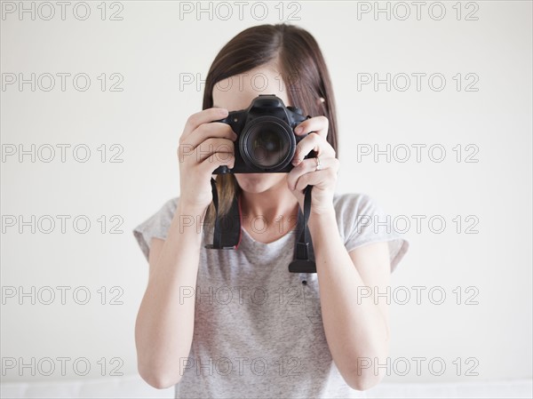 Young woman playing with digital camera. 
Photo : Jessica Peterson