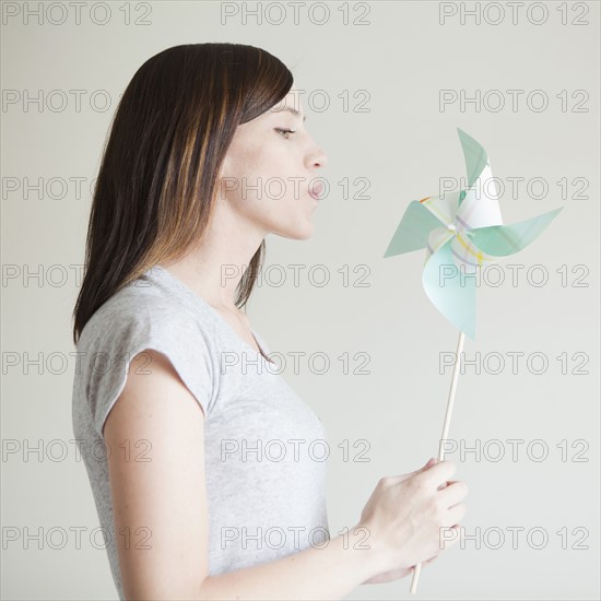 Young woman blowing at paper fan. 
Photo : Jessica Peterson