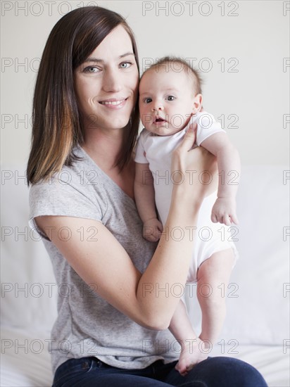 Mother embracing baby girl (2-5 months). 
Photo : Jessica Peterson