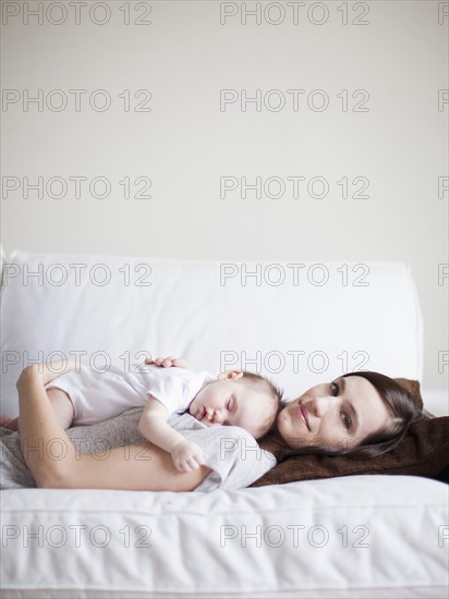 Mother embracing sleeping baby girl (2-5 months) . 
Photo: Jessica Peterson