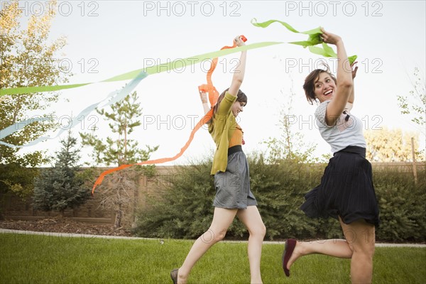 Two happy female friends playing in domestic garden.
Photo : Jessica Peterson