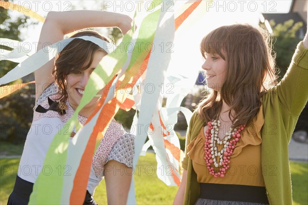 Two happy female friends playing in domestic garden. 
Photo : Jessica Peterson