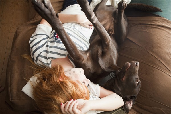 Young woman and her dog sleeping on sofa.
Photo : Jessica Peterson