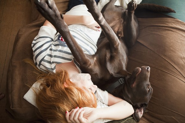 Young woman and her dog sleeping on sofa. 
Photo : Jessica Peterson