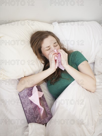 Ill young woman staying in bed. 
Photo : Jessica Peterson