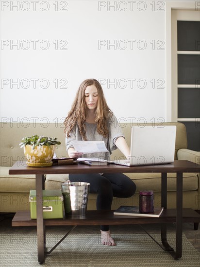 Young attractive woman using laptop while sitting on sofa. 
Photo: Jessica Peterson