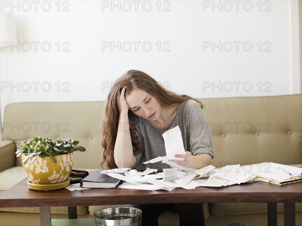 Young woman going though domestic paperwork. 
Photo : Jessica Peterson