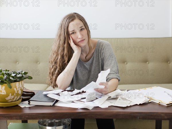 Young woman going though domestic paperwork. 
Photo : Jessica Peterson