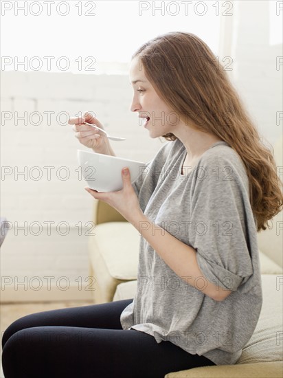 Happy young woman enjoying bowl of cornflakes. 
Photo: Jessica Peterson