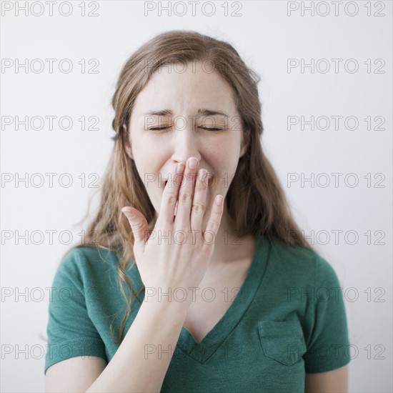 Studio shot of happy young woman yawning. 
Photo: Jessica Peterson