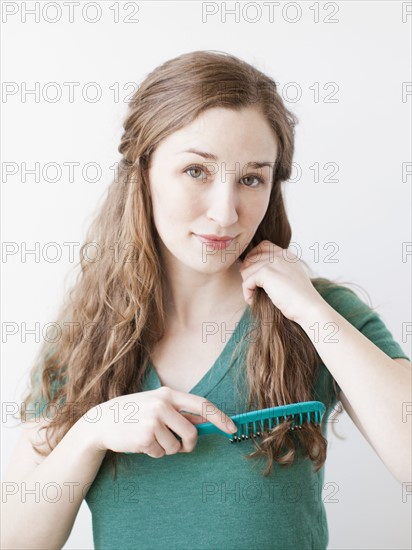 Attractive young woman combing hair. 
Photo: Jessica Peterson