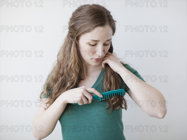 Attractive young woman combing hair. 
Photo: Jessica Peterson