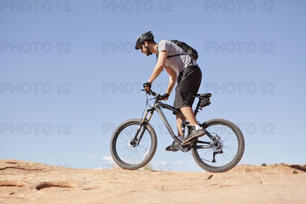 USA, Utah, Moab, Mid adult man riding mountain bicycle in remote scenery. 
Photo : Jessica Peterson