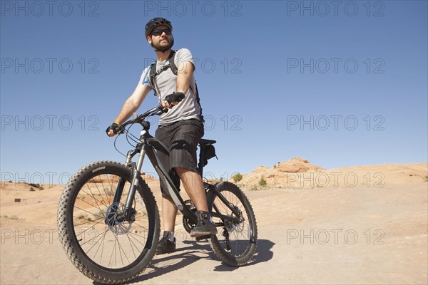 USA, Utah, Moab, Mid adult man riding mountain bicycle in remote scenery. 
Photo : Jessica Peterson