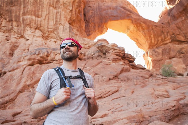 USA, Utah, Moab, Mid adult man posing in front of natural arches. 
Photo : Jessica Peterson
