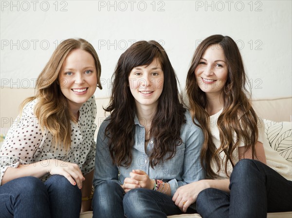 Three young female friends sitting on sofa. 
Photo: Jessica Peterson
