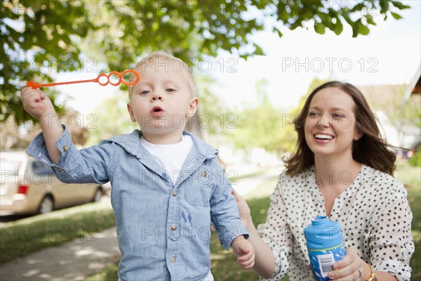Toddler boy (2-3) and mother blowing bubbles. 
Photo: Jessica Peterson