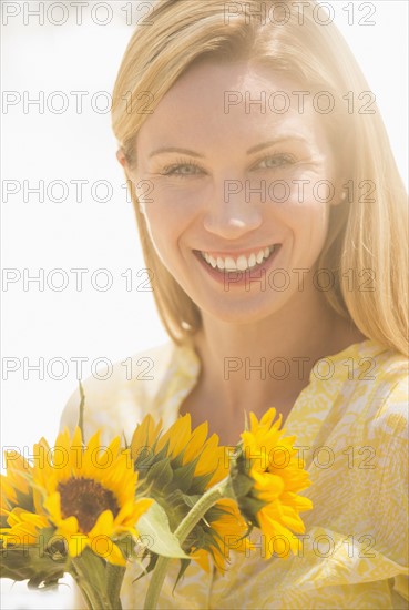 Woman holding sunflowers.