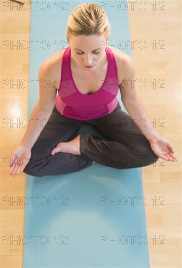 Woman exercising on mat.