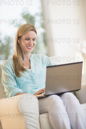 Woman listening to music from laptop.