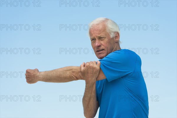 Senior man stretching outdoors.