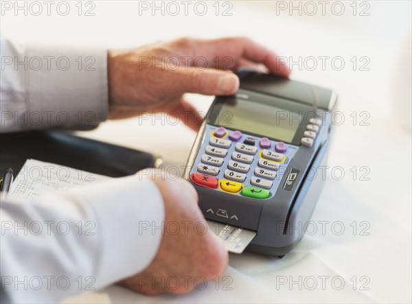 Man inserting credit card in credit card machine.