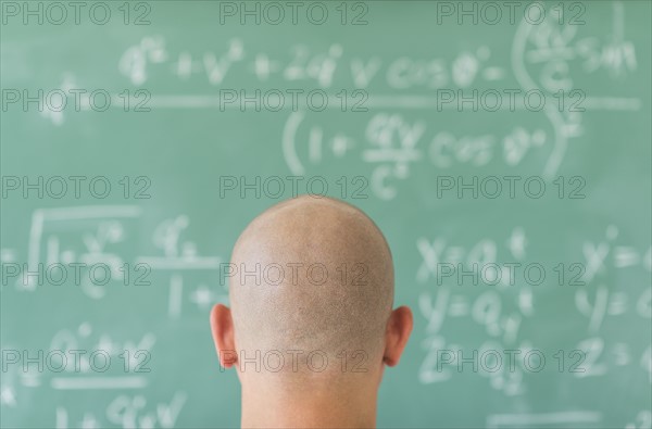 Man in front of blackboard with formulas.