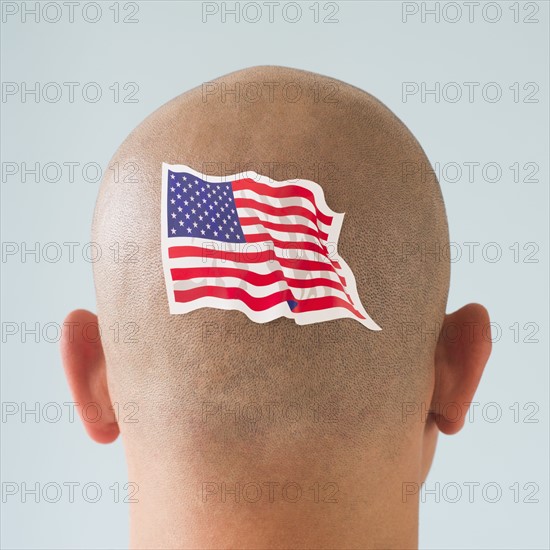 Back view of man with American flag tattoo on head.