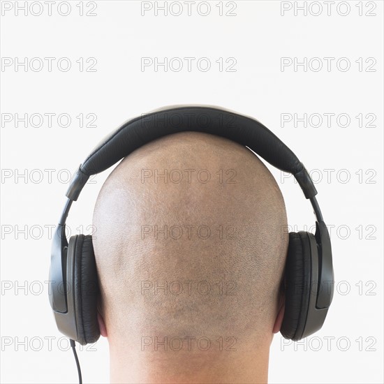 Back view of man with headphones on head.