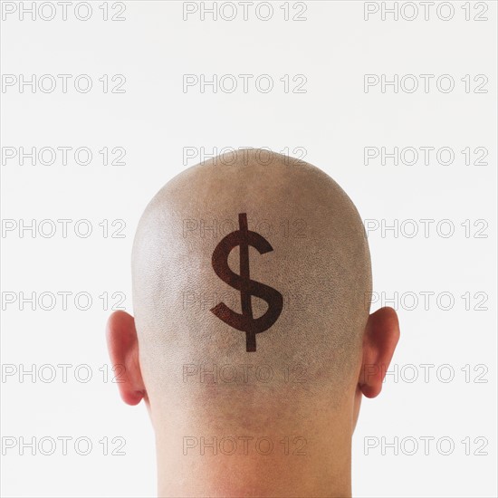 Back view of man with dollar sign on shaved head.