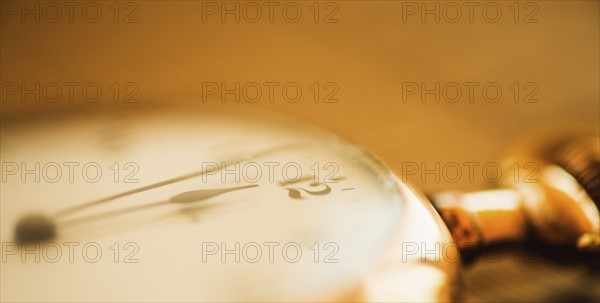 Close-up shot of pocket watch in yellow monochrome.