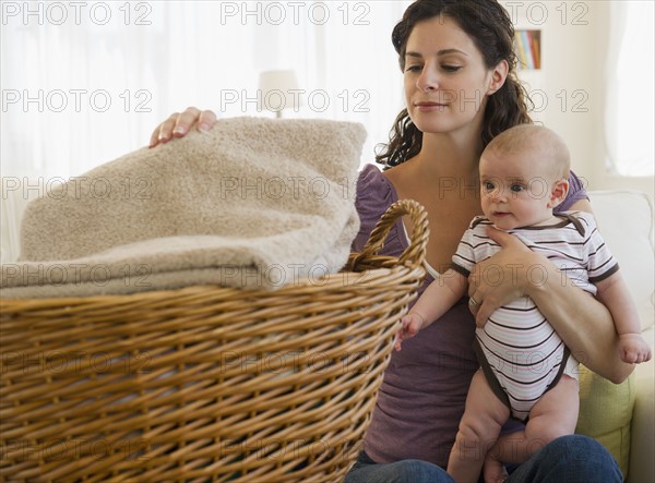 Mother and baby boy (2-5 months) doing laundry. Photo: Jamie Grill