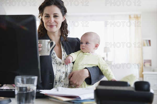 Mother with baby boy (2-5 months) working from home. Photo : Jamie Grill