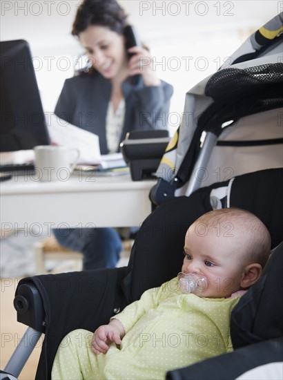 Mother with baby boy (2-5 months) working from home. Photo : Jamie Grill