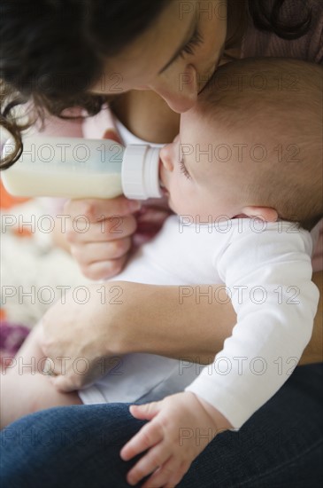 Mother feeding baby boy (2-5 months) using feeding bottle. Photo: Jamie Grill