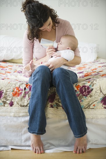 Mother feeding baby boy (2-5 months) using feeding bottle. Photo: Jamie Grill