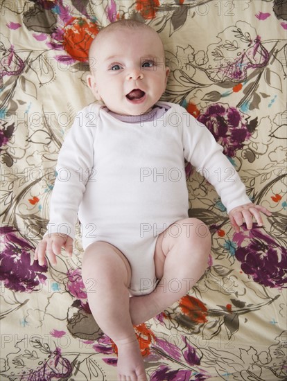 Baby boy (2-5 months) lying on bed. Photo : Jamie Grill